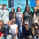 International student group poses in front of a mural